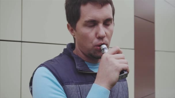Человек, использующий продвинутый личный испаритель или электронную сигарету замедленной съемки — стоковое видео