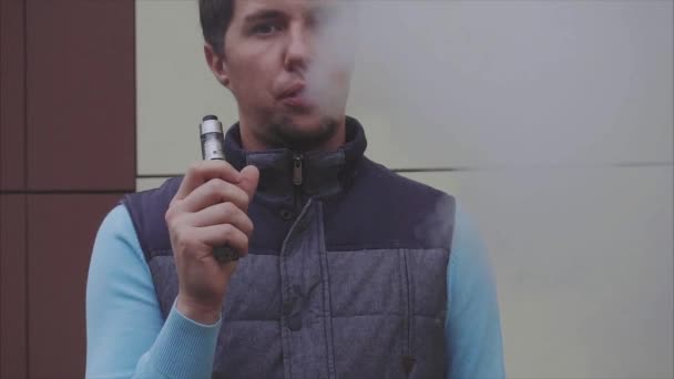 Young man is vaping outdoor slow motion — Stock Video