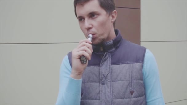 Fiatal férfi vaping egy elektronikus cigaretta. Vaper füst csípő párologtató. — Stock videók