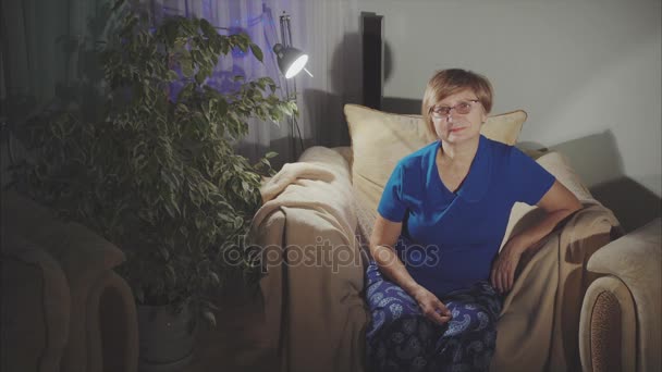 Portrait de femme âgée heureuse assise dans le fauteuil à la maison — Video