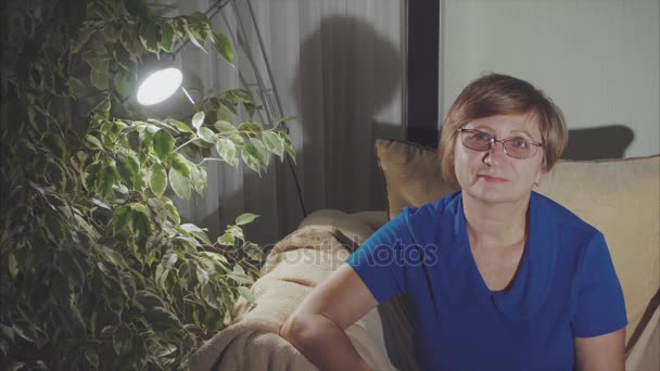 Retrato de mujer de mediana edad sonriendo sentada en el sillón — Vídeos de Stock