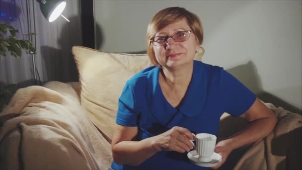 Feliz sênior mulher beber chá sentado na cadeira — Vídeo de Stock