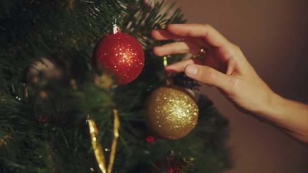 Las manos de la mujer juegan con la pelota en el árbol de Navidad de cerca — Vídeos de Stock