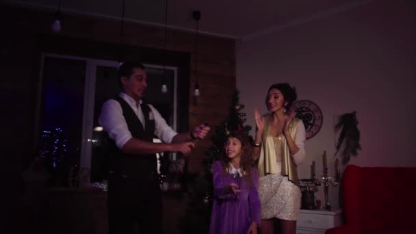 Mother and daughter looking at father making confetti firework with a cracker — Stock Video