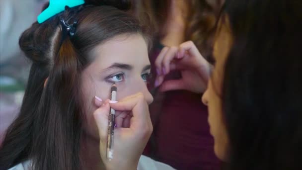 Make-up artiest toepassing van oogschaduw terwijl Haarstylist maken hair-do. — Stockvideo