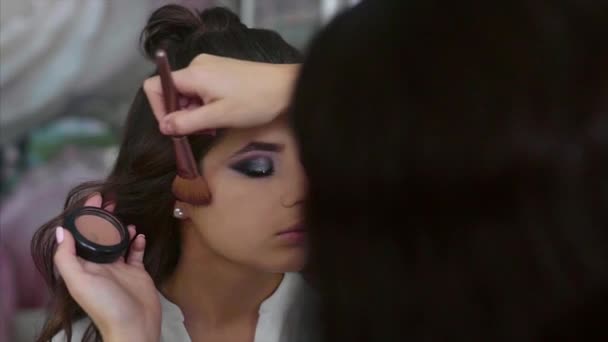 Maquillaje artista aplicar rubor en el modelo pómulos — Vídeo de stock