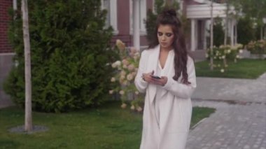 Onun smartphone kullanarak sokakta yürürken başarılı genç iş kadını