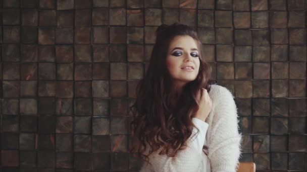 Retrato de una joven mujer bonita con maquillaje brillante posando, mirando a la cámara — Vídeos de Stock