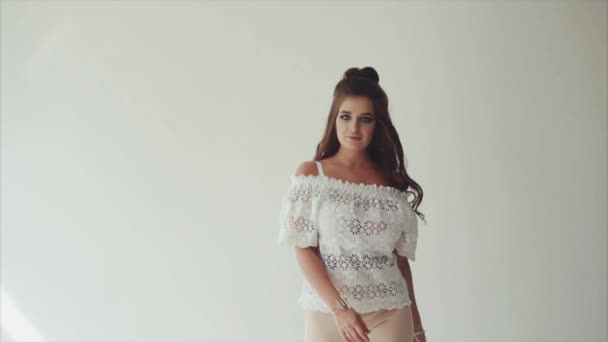 Pretty woman brunette posing in studio on white background and walking to camera — Stock Video