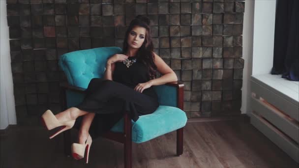 Young pretty wistful brunette woman posing sitting in the armchair — Stock Video