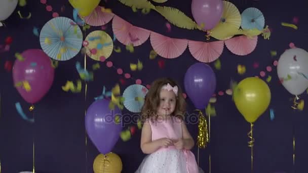 Bonito pequena menina aroud confete e decorações em sua festa de aniversário — Vídeo de Stock