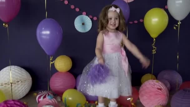 Hübsches kleines Mädchen lacht und spielt auf ihrer Geburtstagsparty — Stockvideo
