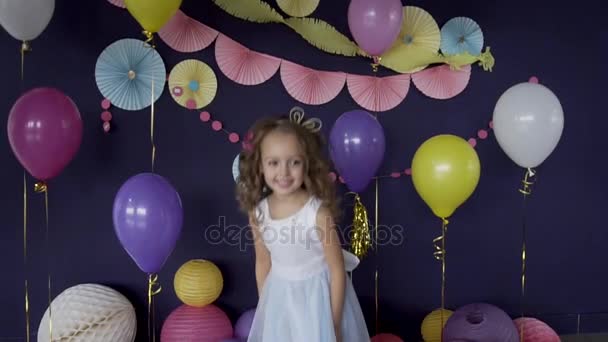 Hübsches kleines Mädchen hüpft unter hellem Konfetti und feiert ihre Geburtstagsparty — Stockvideo