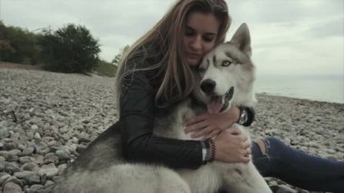 Sibirya husky köpek'ın kıyısında oturan genç çekici kızla