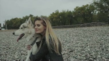 Sibirya husky köpek sahil üzerinde oturan genç şirin kızla