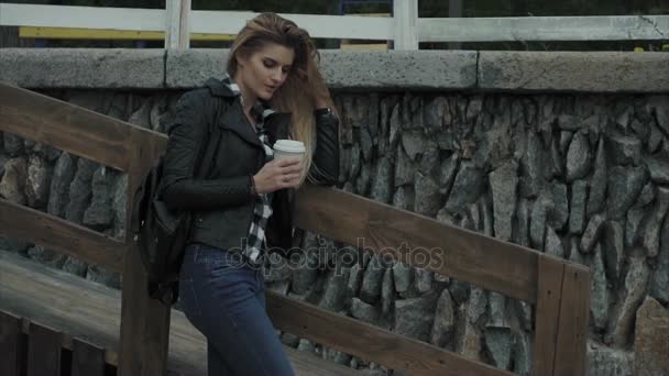 Atrakcyjna blondynka młoda kobieta picia kawy odkryty — Wideo stockowe