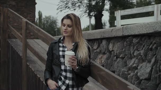 Mujer bonita con una taza de café al aire libre. Hermosa chica disfrutando de su mañana . — Vídeo de stock