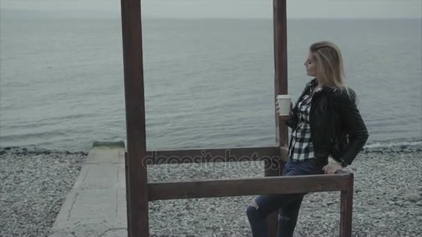 Primer plano de la mujer rubia bebiendo café y mirando al mar — Vídeo de stock