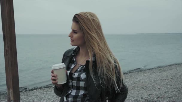 Mujer bonita bebiendo café mirando al mar — Vídeo de stock