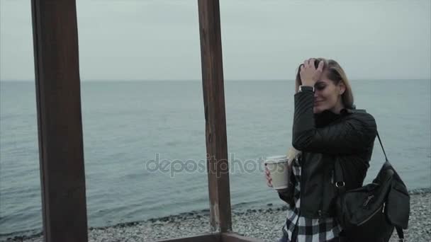 Hermosa joven bonita mujer bebiendo café en la playa orilla del mar — Vídeo de stock