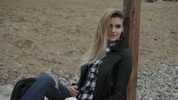 Junge hübsche Frau sitzt auf Holzsteg und träumt von der Zukunft — Stockvideo