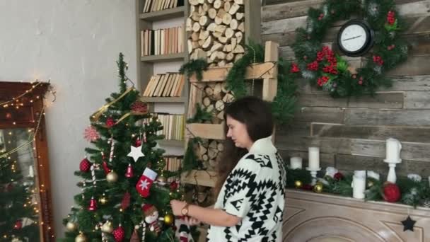 Mooie vrouw de kerstboom te verfraaien — Stockvideo