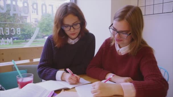 Női főiskolai hallgatók tanulnak a kávézóban két lány barátok tanul együtt — Stock videók