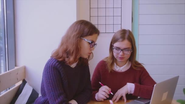 Estudiantes universitarias estudian en la cafetería dos amigas aprendiendo juntas — Vídeos de Stock