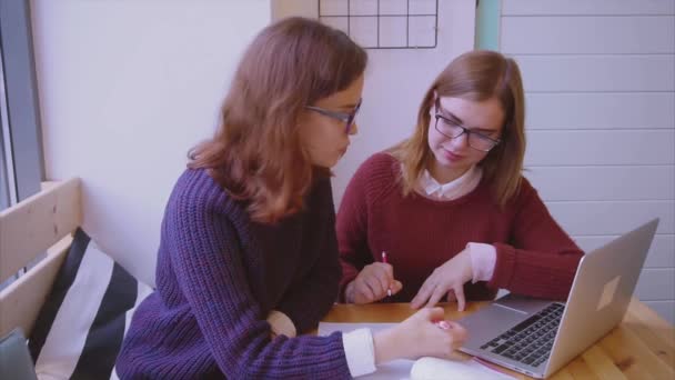 Estudiantes universitarias estudian en la cafetería dos amigas aprendiendo juntas — Vídeos de Stock