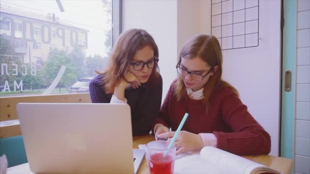 Estudiantes universitarias estudian en la cafetería dos amigas aprendiendo juntas — Vídeos de Stock