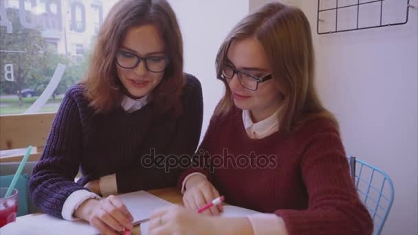 Estudiantes universitarias estudian en la cafetería dos amigas aprendiendo juntas — Vídeos de Stock