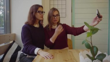 İki güzel kız bir selfie kapalı kafe için poz