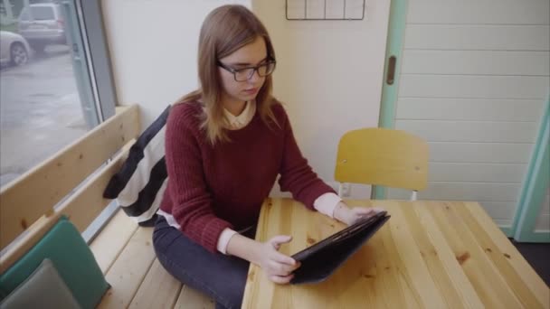 Menina estudante bonita usando telefone tablet no café — Vídeo de Stock