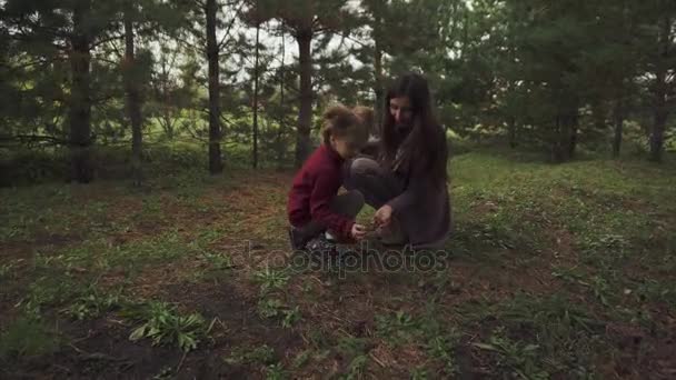 Madre e hija buscando bultos en el bosque — Vídeo de stock