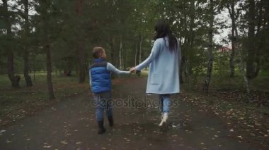 Anne ve oğlu sonbahar parkta yürüyüş