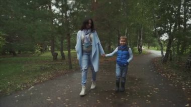 Anne ve oğlu sonbahar parkta yürüyüş