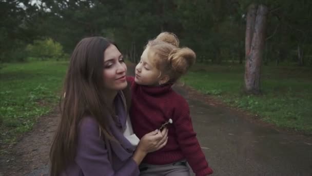 Figlia bacio sua madre mentre trascorrono del tempo nel parco autunnale . — Video Stock