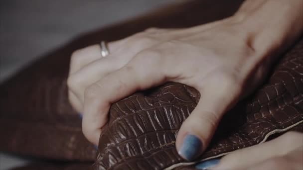 Женские руки сжимают кожаную подушку от боли — стоковое видео