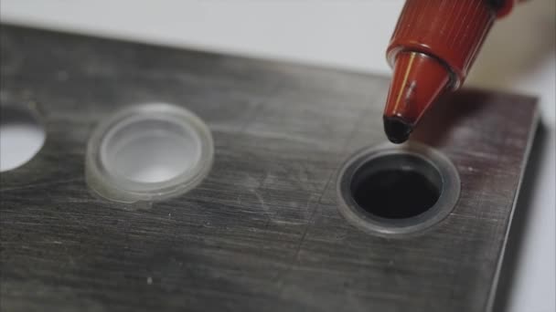 Close up shot of tattoo master dropping ink into the container