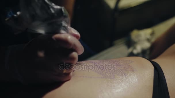 Крупный план рук татуировщика в перчатках, татуирующих рисунок на макросах тела — стоковое видео