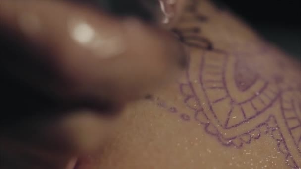 Gros plan des mains de tatoueur dans des gants tatouant un motif sur le corps macro — Video