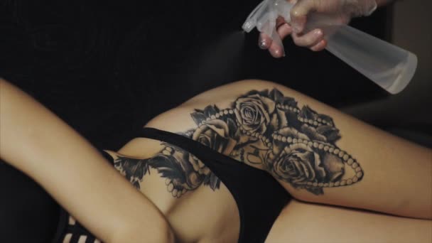 Tattoo artist preparing skin of his client to the process of making tattoo — Stock Video