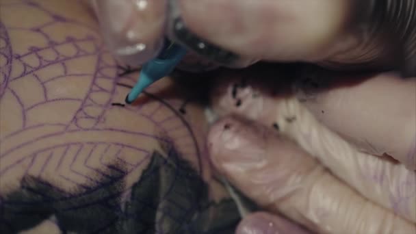 Detail z rukou tetování umělce v rukavicích tetování vzor na těle makra — Stock video