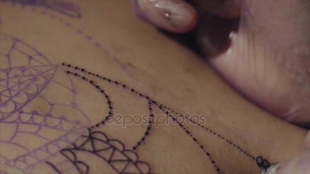 Primo piano delle mani del tatuatore in guanti che tatuano un modello sulla macro del corpo — Video Stock