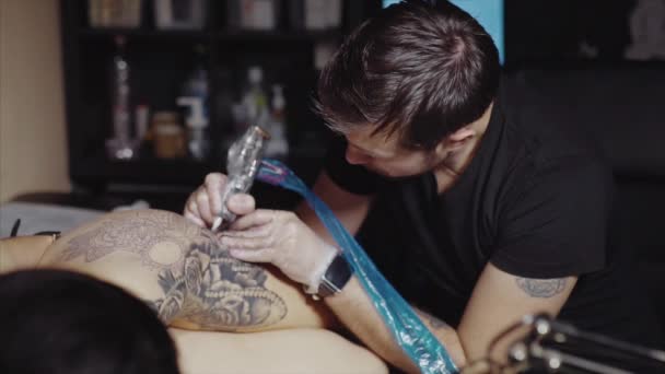 Татуировщик делает татуировку в студии — стоковое видео