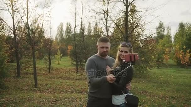 Пара робить селфі в осінньому парку — стокове відео