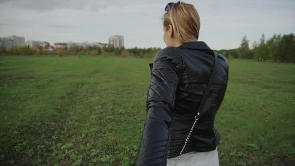Молодая женщина тащит своего парня через осенний парк — стоковое видео