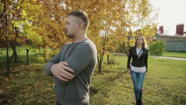 若い幸せなカップルを満たす秋の公園で — ストック動画
