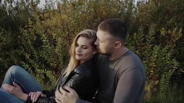 Fiatal pár élvezi minden más ül a gyep őszi parkban — Stock videók