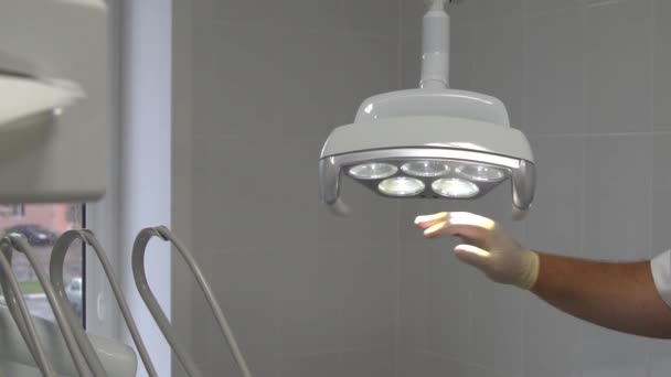 Dentallampe schaltet sich durch Berührung des Sensors ein und leuchtet direkt an der Kamera — Stockvideo